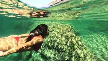 Fuerteventura, Kanarya Adaları 'ndaki Doğal Yüzme Havuzları' nın berrak turkuaz sularında yüzen kadın Aguas Verdes gerçek zamanlı hareket halinde yakalanır.