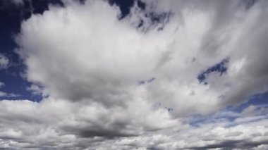 Zaman ayarlı bir video, değişken bulutları gösteriyor. Canlı mavi bir gökyüzünde süzülen, gerçek zamanlı atmosferik hareketleri tasvir eden..