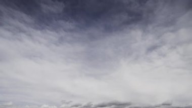Değişik bulut oluşumlarının hızlı hareketlerini gösteren dramatik bir zaman dilimi videosu canlı mavi bir gökyüzünde gerçek zamanlı değişen hava modellerini yakalıyor..