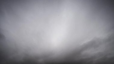 Gökyüzünde yoğun, karanlık fırtına bulutlarının dramatik ve hızlı bir şekilde toplandığını gösteren bir zaman kaydıyla yaklaşan fırtınayı gösteriyor..