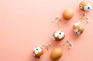 Paskalya yumurtaları pastel pembe arka planda çiçekleri süsledi. Düz konum, üst görünüm, kopyalama alanı. Mutlu Paskalyalar.