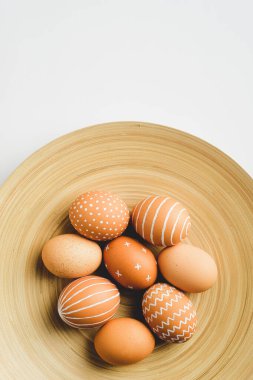 Beyaz arka planda zarif tabakta basit Paskalya yumurtaları. Mutlu Paskalyalar.