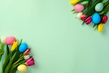 Yeşil arka planda lale çiçekli Paskalya yumurtaları. Düz konum, üst görünüm, kopyalama alanı