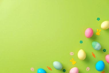 Parlak yeşil arka planda renkli Paskalya yumurtaları ve konfeti. Paskalya tebrik kartı şablonu
