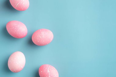 Turkuaz arka planda pembe Paskalya yumurtaları. Düz konum, üst görünüm, kopyalama alanı. Mutlu Paskalya Minimum Konsepti.