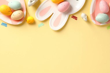 Paskalya yumurtaları ve sofra takımlarıyla dolu mutlu paskalya çerçeveleri. Düz yatış, üst görünüm.