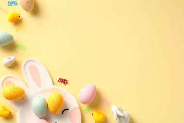 Paskalya yumurtaları, dekoratif tavuklar, pastel sarı masadaki tavşanlar....