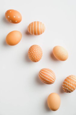 Beyaz arka planda basit bir Paskalya yumurtası. Düz, üst görünüm, dikey. Asgari biçim.