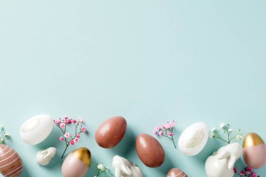 Zarif Paskalya yumurtaları, minimalist çiçekler, pastel mavi arka planda dekoratif tavşanlar. Paskalya bayrağı tasarımı. Düz yatış, üst görünüm.