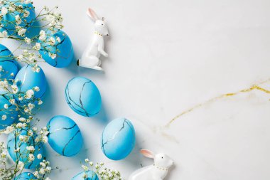 Çiçekli doğal Paskalya Yumurtaları ve mermer arka planda tavşan süslemeleri..
