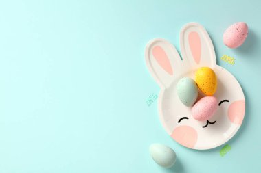 Paskalya bayrağınız kutlu olsun. Paskalya tavşanı şeklinde renkli Paskalya yumurtaları tabakta. Üst Manzara. Düz yatıyordu.