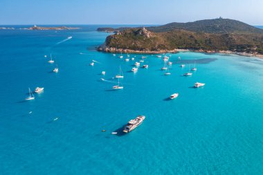 Yazın güneşli bir günde mavi denizde lüks yatların ve teknelerin hava manzarası. Sardunya, İtalya 'ya seyahat. Sürat tekneleri, yatlar, deniz koyları, kayalık kıyılar, şeffaf su. Deniz Burnu