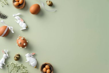 Mutlu Paskalyalar. Paskalya yumurtaları, bıldırcın yumurtaları, çingene çiçekleri, Paskalya tavşanları, pastel yeşili arka planda tüyler