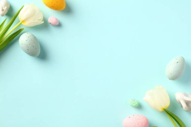 Mutlu Paskalya tebrik kartı şablonları. Renkli yumurtalar ve pastel masanda beyaz laleler olan Paskalya bayrağı tasarımı. Düz yatış, üst görünüm.
