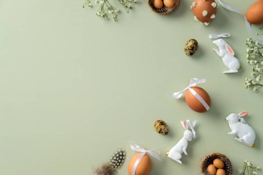 Mutlu Paskalyalar. Süslü Paskalya yumurtaları, bıldırcın yumurtaları, çingene çiçekleri, Paskalya tavşanı, pastel yeşil zemindeki tüyler....