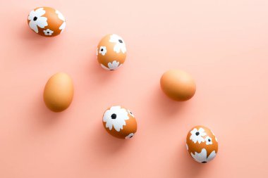 Pastel pembe arka planda Paskalya yumurtaları olan yaratıcı bir düzen. Mutlu Paskalyalar.