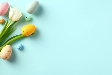 Mutlu Paskalya bayrağı tasarımı. Paskalya yumurtaları ve beyaz laleler mavi arka planda çiçek açarlar..