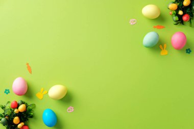 Mutlu Paskalya tebrik kartı tasarımları. Üst manzara renkli Paskalya yumurtaları, tavşan kağıtları ve yeşil arka planda şenlikli dekorasyonlar..