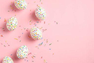 Mutlu Paskalyalar. Pembe arka planda renkli benekli paskalya yumurtalarından yapılmış çerçeve. Düz konum, üst görünüm, kopyalama alanı.