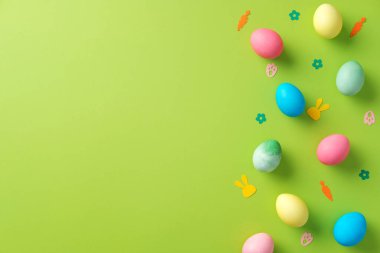 Renkli yumurtalar ve canlı yeşil masada konfeti ile soyut Paskalya arkaplanı. Paskalya bayrağı tasarımı, tebrik kartı şablonu. Asgari biçim.