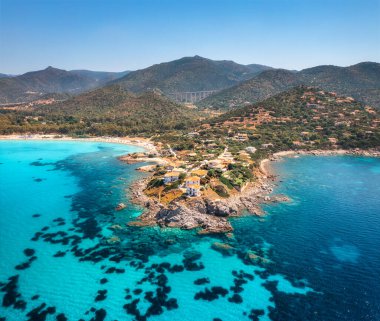 Adanın havadan görünüşü, deniz körfezi, sahil, yaz güneşli bir günde tekneler. Sardunya, İtalya 'ya seyahat. Kayalık sahilin, dağın, köyün, deniz lagünün, şeffaf gök mavisi suyun, gökyüzünün en üst manzarası. Deniz Burnu