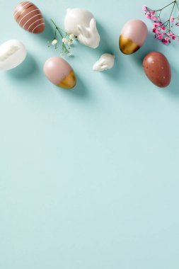 Mutlu Paskalya bayrağı dikey tasarımı, poster şablonu. En üst sınır çerçevesi paskalya yumurtaları, çiçekler, pastel mavi arka planda tavşanlar
