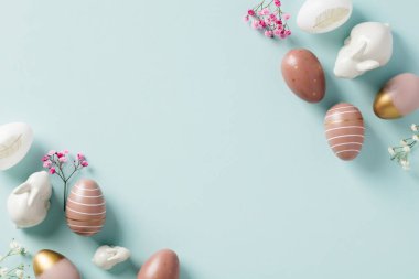Mutlu Paskalya bayrağı tasarımı. Süslü Paskalya yumurtaları, dekoratif tavşanlar, pastel mavi masada asgari çiçekler..