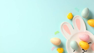 Paskalya bayrağınız kutlu olsun. Mavi arka planda Paskalya tavşanı şeklinde paskalya yumurtası ve tabağı.