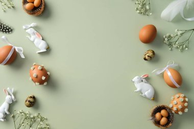 Mutlu Paskalya kompozisyonu. Paskalya yumurtaları, bıldırcın yumurtaları, çingene çiçekleri, Paskalya tavşanı, pastel yeşil arka planda tüyler..