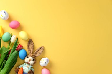 Mutlu Paskalyalar. Renkli yumurtalar, laleler ve dekoratif Paskalya tavşanlarıyla bezenmiş düz bir kompozisyon