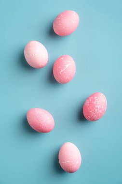 Pembe Paskalya yumurtaları turkuaz arka plan. Asgari düzeyde. Düz, üst görünüm, dikey