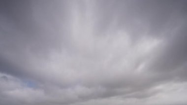 Zaman atlamalı bir videoda kaydedilen dinamik bulut hareketleriyle bulutlu gökyüzü, gerçek zamanlı olarak değişen hava modellerini gösteriyor.