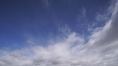 Geniş bir gökyüzünde bulutların dinamik hareketlerini gösteren geniş açılı bir zaman çizelgesi. Bulut desenlerinin ve ışığın gerçek zamanlı değişimlerinin doğal güzelliğini yakalıyor..