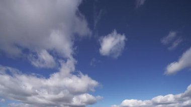 Gerçek zamanlı bir video, dinamik hareketleri ve bulutların oluşumlarını canlı mavi gökyüzüne karşı göstererek doğal güzelliği ve atmosferik değişimleri yakalıyor..