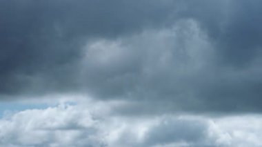 Karanlık, fırtınalı bir gökyüzünde hızlı hareket eden ve kara kara kara düşünen bulutları yakalayan dinamik bir zaman dilimi videosu havanın gücünü ve geçici doğasını gösteriyor..