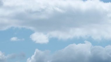 Saf mavi gökyüzünde beyaz bulutların hızlı hareketini kaydeden bir zaman kaydıyla, havanın barışçıl ama dinamik doğasını gösteriyor..
