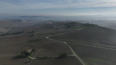 İtalya 'nın Marche şehrinde bulunan Treia şehrinin etrafındaki hareketli tepeleri gösteren büyüleyici hava aracı görüntüleri.