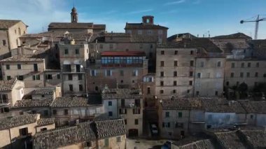 İtalya 'nın Marche ilinde bulunan büyüleyici Treia kentindeki güneşli çatıların ve tarihi mimarinin insansız hava aracı görüntüleri. Gerçek zamanlı hareket, sisle kaplı sakin bir sabah atmosferini yakalıyor.