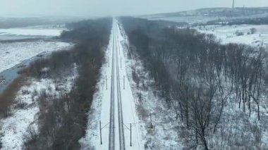 Ukrayna 'nın kışın ortasında karla kaplı demiryolu manzarası. Sahne, devam eden çatışma bölgesinin ortasında sessiz bir yalnızlık hissi veriyor.