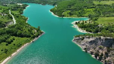 İtalya 'nın pitoresk Marche bölgesinde yemyeşil tepelerle çevrili çarpıcı bir turkuaz göl yakalıyor ve sakin ve sakin bir manzara sunuyor.