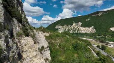 İtalya 'nın görkemli Marş bölgesinde yemyeşil tepeler ve parçalı bulutlu bir gökyüzünün altındaki kayalık kayalıkların manzarası doğal güzellik ve sükuneti gözler önüne seriyor.