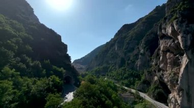 İtalya 'nın Marche bölgesindeki tuhaf bir köyü çevreleyen yemyeşil kaplı, yemyeşil dağların parlak, berrak bir gökyüzü altında yakalanmış nefes kesici bir manzarası.