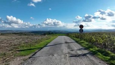 İtalya 'nın Marş bölgesindeki sakin manzara, hareketli mavi bulutların altında yuvarlanan tepelerin arasından geçen, seyahat için mükemmel bir ilham kaynağı olan pitoresk bir yol sergiliyor.