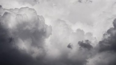 Değişen bir fırtınanın dinamik gücünü ortaya koyan zıt ışık ve karanlık tonlarla gökyüzünde dönen ve dönen kümülüs bulutlarının karamsar, yakın çekim hızlandırılmış hali.