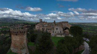 İtalya 'nın orta kesimindeki Treia tepesinin insansız hava aracı görüntüsü, Marche bölgesinde dramatik bir gökyüzü altında ortaçağ binaları, kuleler ve kırsal alanlara ev sahipliği yapıyor.