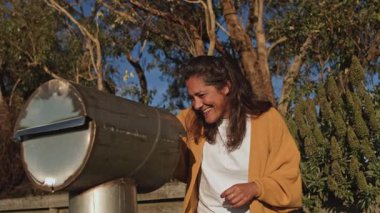 Posta kutusunun yanında neşeli bir ifadeyle mektuplar tutan bir kadın var. Sahne, mektupları kontrol ederken günlük rutininde bir sürpriz ve mutluluk anı yakalıyor.