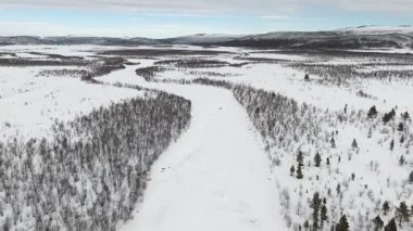 İsveç 'in Kiruna kenti yakınlarındaki geniş karlı manzaraları gösteren çarpıcı bir hava aracı videosu. Görüntülerde, kar örtüsünün altındaki uçsuz bucaksız el değmemiş el değmemiş vahşi doğa sergileniyor ve sakin bir kış sahnesi yaratılıyor..