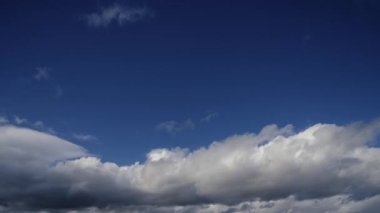 Geniş mavi gökyüzünde bulutların dinamik hareketlerini yakalayan bir zaman kaydıyla atmosferin doğal ritmini ve akışını vurguluyoruz..