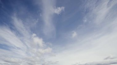 Zaman çizelgesi bulutları canlı mavi gökyüzünde yakalıyor, şiddetli değişimleri ve çapraz rüzgarlardan güç alan dönüşümleri vurguluyor..