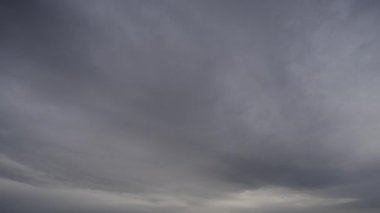 Gökyüzündeki yoğun, karanlık fırtına bulutlarının dramatik ve hızlı bir şekilde toplandığını gösteren bir zaman kaydıyla..